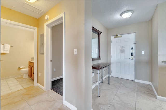 entrance foyer with light tile patterned flooring and a textured ceiling