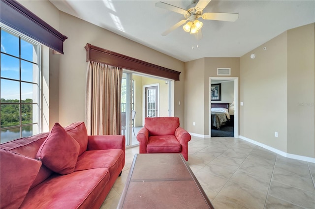 living room featuring light tile patterned floors and ceiling fan