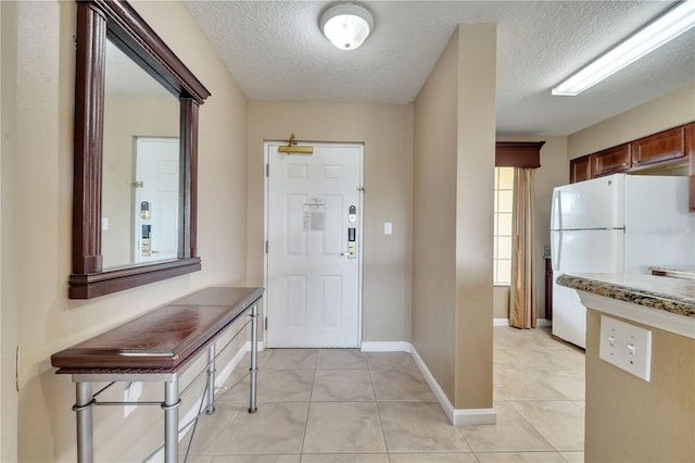 tiled foyer featuring a textured ceiling