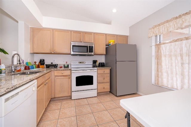 kitchen featuring appliances with stainless steel finishes, light brown cabinetry, sink, light tile patterned floors, and lofted ceiling