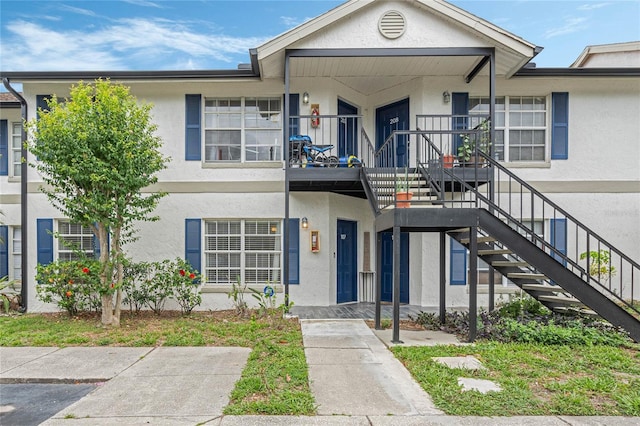 view of property with stucco siding and stairs