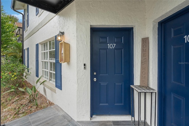 view of exterior entry featuring stucco siding