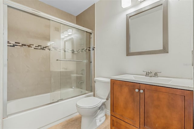 bathroom featuring vanity, toilet, tile patterned flooring, and bath / shower combo with glass door
