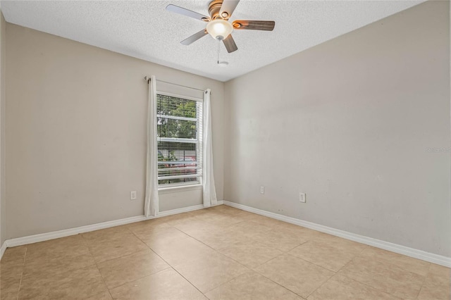 spare room featuring a textured ceiling, ceiling fan, and light tile floors