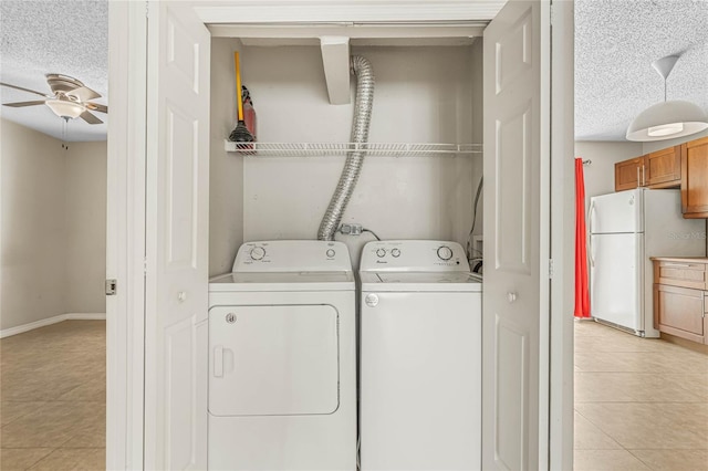 laundry room featuring ceiling fan, hookup for a washing machine, washer and dryer, light tile flooring, and a textured ceiling