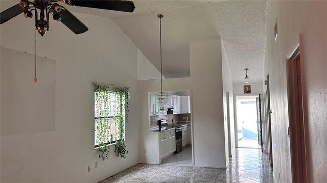 1204 Easton St, Orlando, FL 32825 - kitchen with a ceiling fan, electric range, high vaulted ceiling, white cabinetry, and a textured ceiling