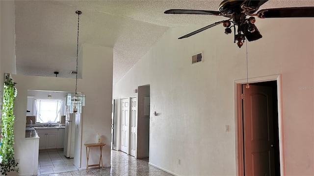 1204 Easton St, Orlando, FL 32825 - unfurnished living room featuring a ceiling fan, a textured ceiling, high vaulted ceiling, baseboards, and light tile patterned flooring