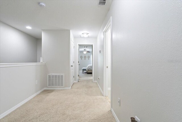 hallway featuring light colored carpet