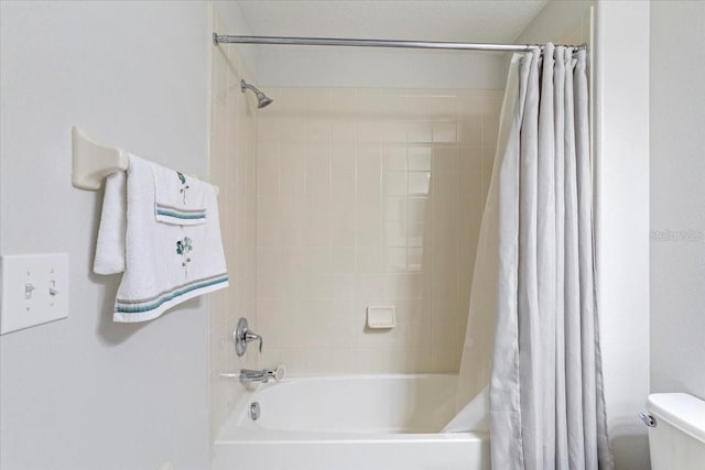 bathroom featuring shower / bath combo and toilet