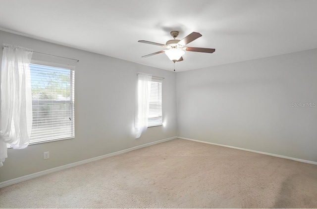 empty room with light colored carpet and ceiling fan