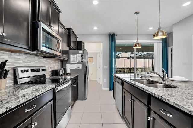 kitchen featuring stainless steel appliances, backsplash, pendant lighting, sink, and light tile flooring