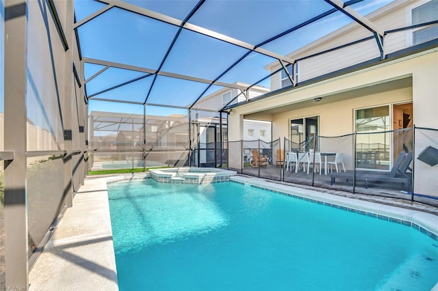 view of pool featuring a patio, glass enclosure, and an in ground hot tub