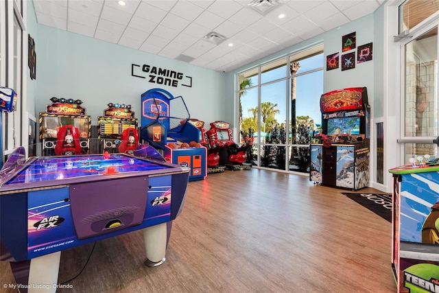 rec room with hardwood / wood-style flooring and a drop ceiling