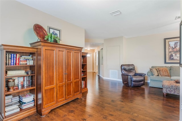 sitting room with dark wood-style floors, visible vents, and baseboards