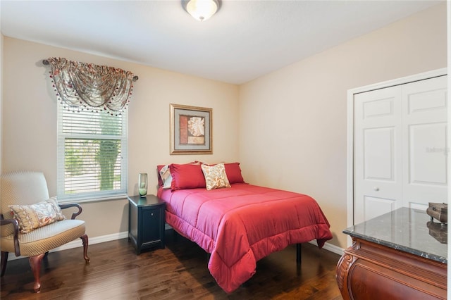 bedroom featuring dark wood-type flooring, a closet, and baseboards