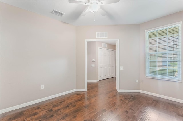 unfurnished room featuring baseboards, visible vents, ceiling fan, and wood finished floors