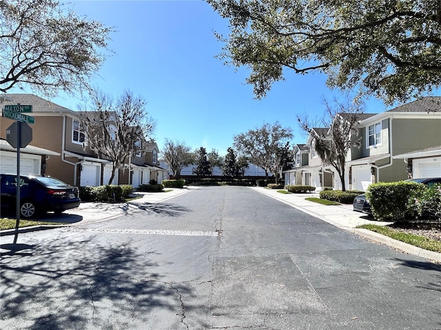 view of road featuring traffic signs, a residential view, and curbs