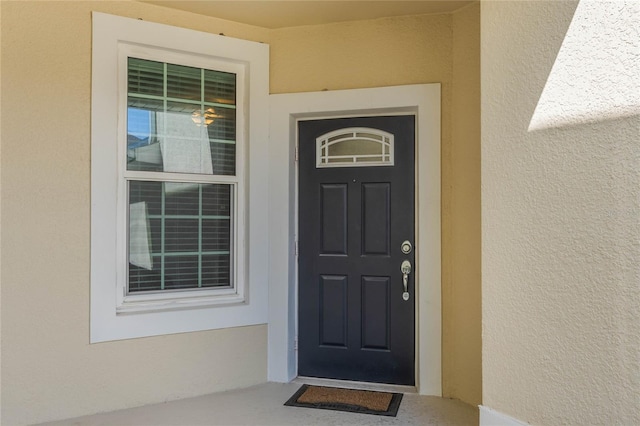 property entrance with stucco siding