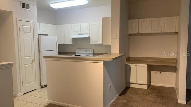 kitchen with white refrigerator, white cabinetry, range, and light tile patterned floors