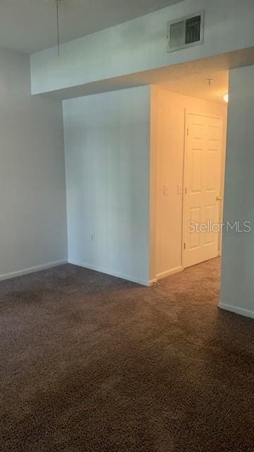 spare room with dark colored carpet