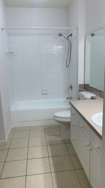 full bathroom with vanity, toilet, tile patterned floors, and tiled shower / bath combo