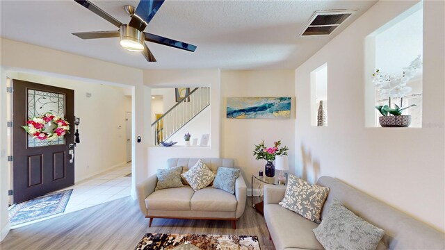 interior space with ceiling fan, light hardwood / wood-style floors, and a textured ceiling