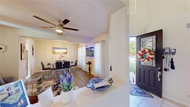 foyer with light wood-type flooring and ceiling fan