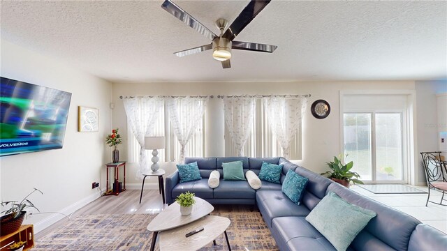 living room with ceiling fan, hardwood / wood-style floors, and a textured ceiling