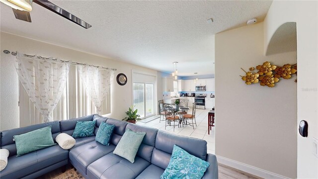 living room featuring a textured ceiling and light hardwood / wood-style flooring