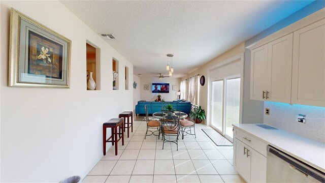 dining room featuring ceiling fan, light tile patterned floors, and a textured ceiling