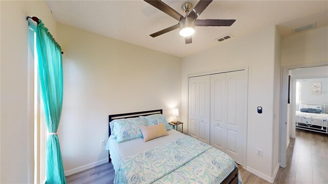 bedroom with ceiling fan, a closet, and hardwood / wood-style flooring