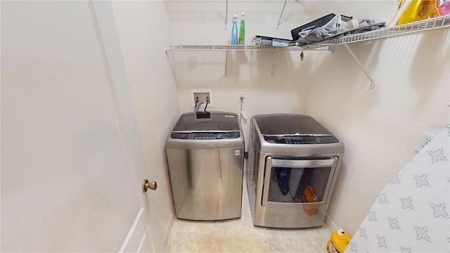 clothes washing area featuring washer and dryer and tile patterned flooring