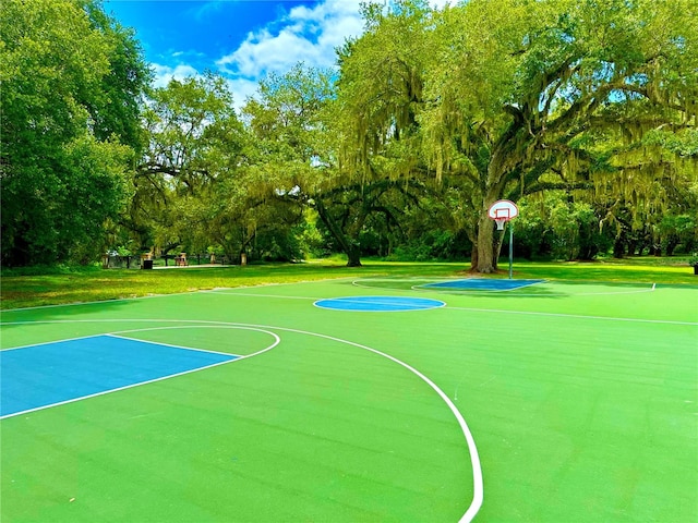 view of sport court with a lawn