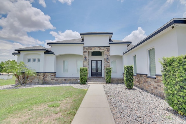 view of front of home with french doors and a front lawn