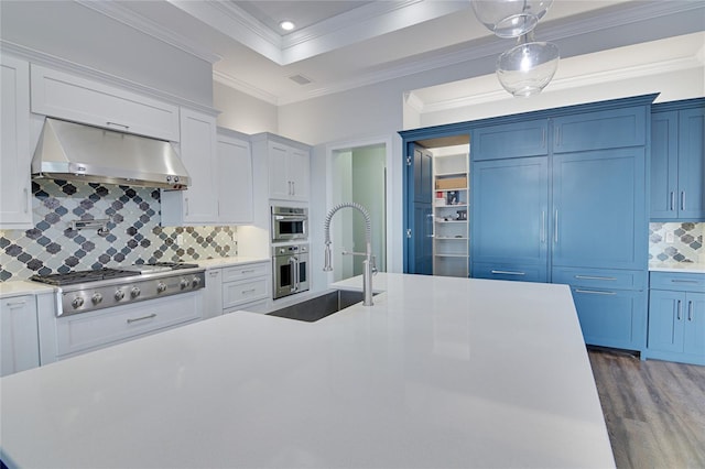 kitchen featuring tasteful backsplash, ventilation hood, stainless steel gas cooktop, sink, and pendant lighting