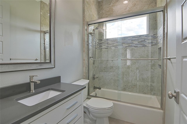 full bathroom featuring shower / bath combination with glass door, vanity, and toilet