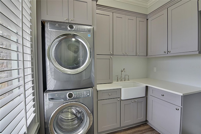 washroom featuring cabinets, a healthy amount of sunlight, sink, and stacked washer and dryer