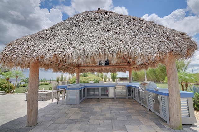 view of patio featuring a gazebo, grilling area, and exterior kitchen