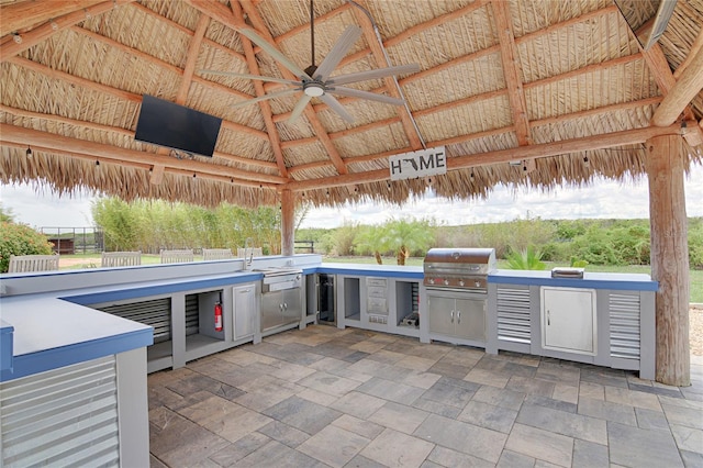 view of patio / terrace featuring a gazebo, grilling area, ceiling fan, and exterior kitchen