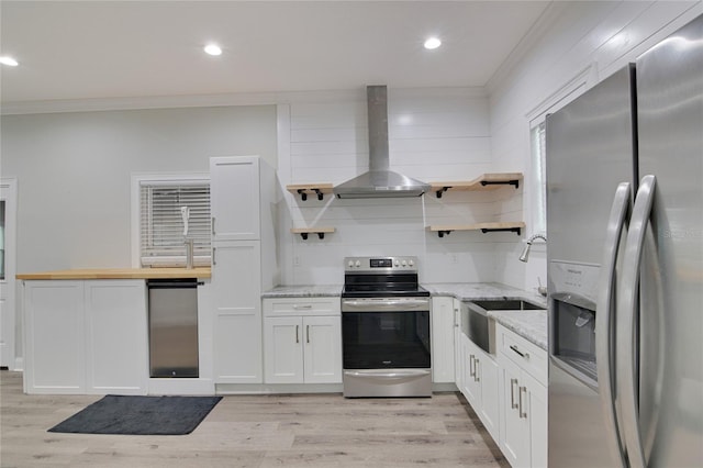 kitchen with white cabinets, sink, light stone countertops, range hood, and stainless steel appliances