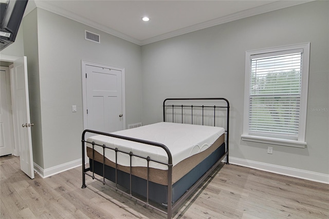 bedroom featuring light wood-type flooring and crown molding