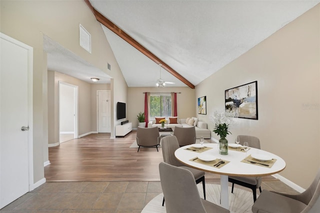 dining area with beamed ceiling, ceiling fan, and high vaulted ceiling