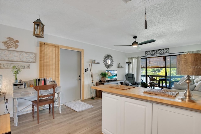 kitchen with butcher block countertops, white cabinetry, a textured ceiling, light wood-type flooring, and ceiling fan