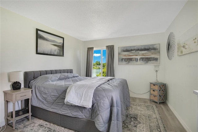 bedroom with hardwood / wood-style flooring and a textured ceiling