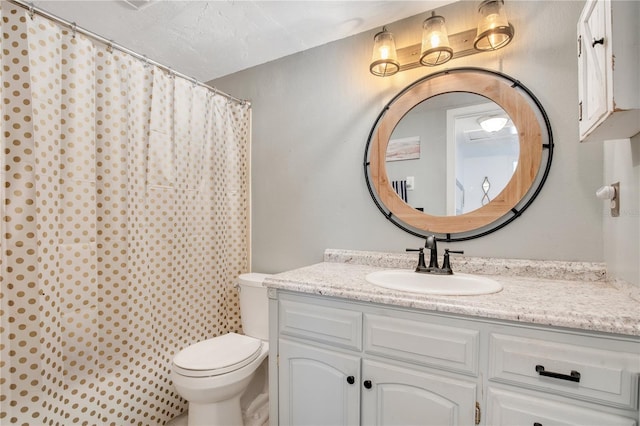 bathroom featuring vanity, walk in shower, and toilet