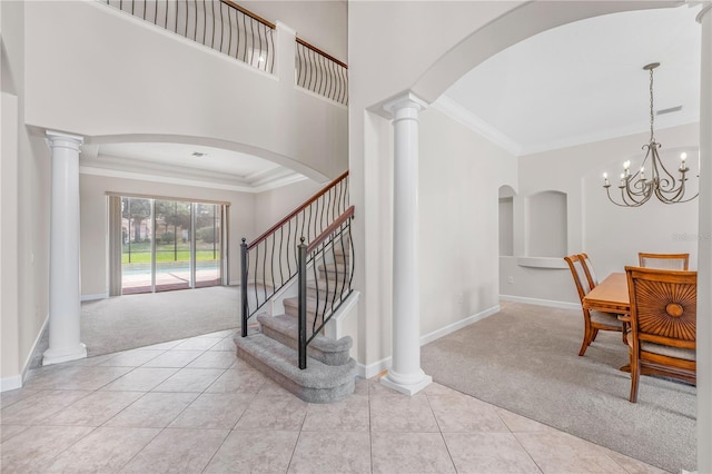 entryway featuring ornate columns, ornamental molding, and light colored carpet