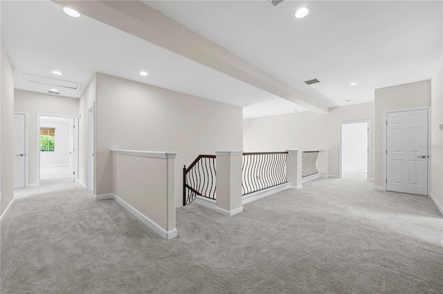 hallway with beam ceiling and light carpet