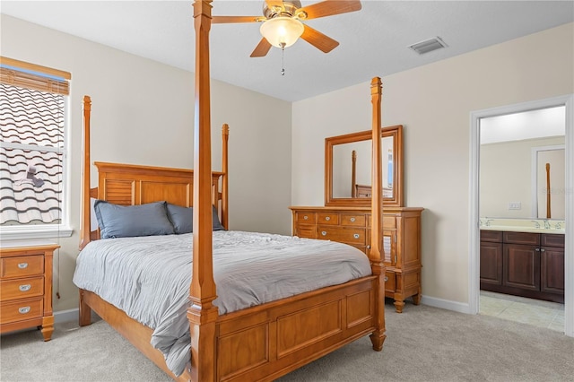 bedroom featuring light carpet, ensuite bathroom, ceiling fan, and sink