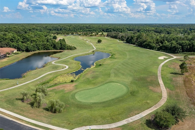 drone / aerial view featuring a forest view, golf course view, and a water view