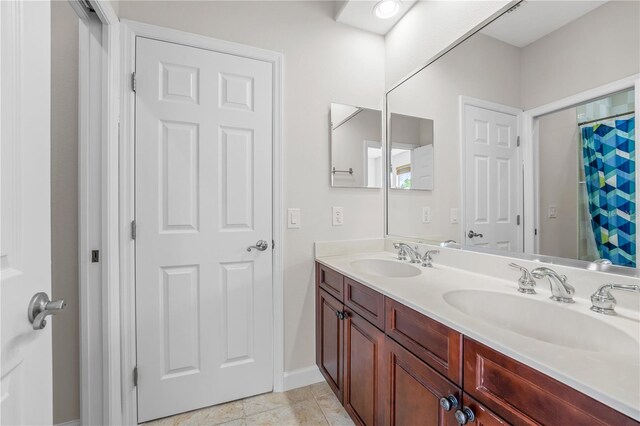 bathroom with tile patterned floors, vanity, and walk in shower